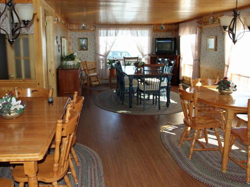 Un comedor con mesas y sillas de madera. en Auberge Motel 4 Saisons, en Blanc-Sablon