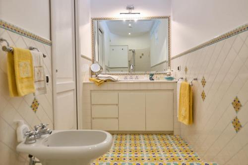 ein Badezimmer mit Waschbecken und Spiegel in der Unterkunft MAGICA VISTA in Amalfi