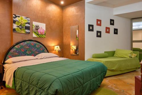 ein Schlafzimmer mit einem grünen Bett und einem Sofa in der Unterkunft MAGICA VISTA in Amalfi