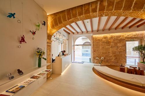 Habitación grande con pared de piedra y techo de madera. en Santa Clara Urban Hotel & Spa, en Palma de Mallorca