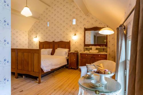 a bedroom with a bed and a mirror and a table at B&B Hostellerie Marie in Eben-Emael