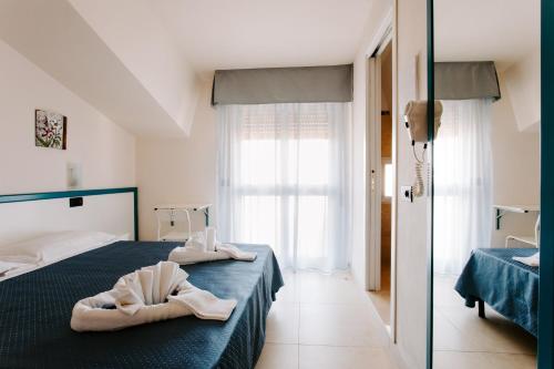 a bedroom with two towels sitting on a bed at Hotel Villa Claudia in Bellaria-Igea Marina