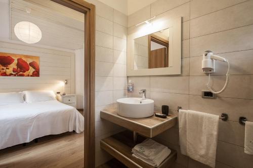 baño con lavabo y cama en Hotel Prealpi, en Castione della Presolana