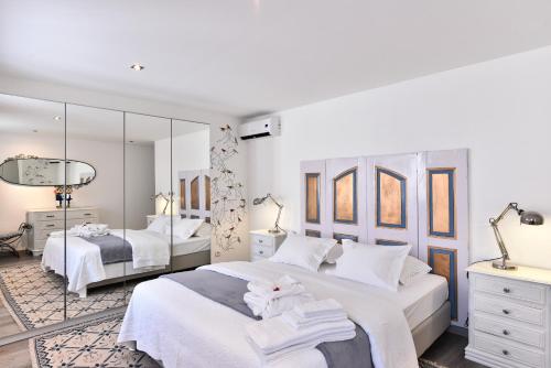 a white bedroom with two beds and a mirror at Feel Discovery Douro Janja in Armamar