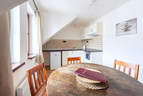 a kitchen with a wooden table with chairs and a dining room at Family Apartments Praha 6 in Prague
