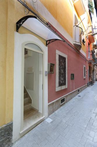a building with an open doorway with a staircase on it at Appartamento Vicolo a mare, Mazzeo in Mazzeo