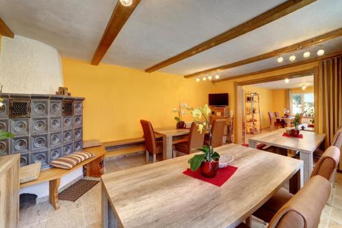 a dining room with a wooden table and chairs at Pension Fohlenhof in Frauenau