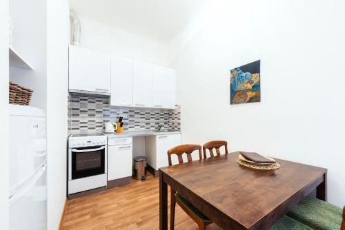a small kitchen with a wooden table and chairs at Family Apartments Praha 6 in Prague