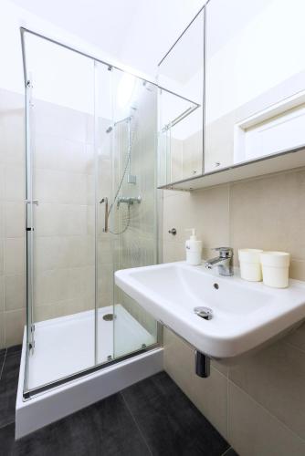 a bathroom with a sink and a shower at Family Apartments Praha 6 in Prague