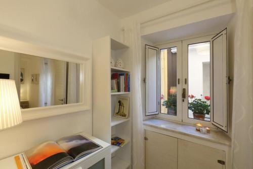 a white room with a window and a book shelf at Appartamento Vicolo a mare, Mazzeo in Mazzeo