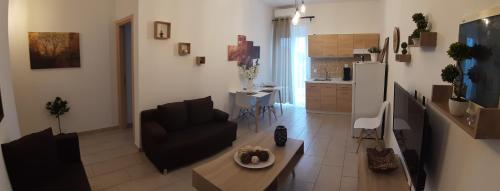a living room with a couch and a table and a kitchen at Skala Pearls A1 in Skala Kefalonias