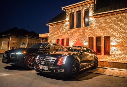 ein schwarzes Auto, das vor einem Haus parkt in der Unterkunft H & V Residence - Diamond Bungalow Apartment in Arad