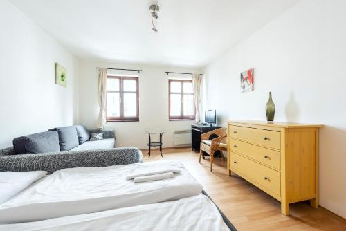 a bedroom with a bed and a couch at Family Apartments Praha 6 in Prague