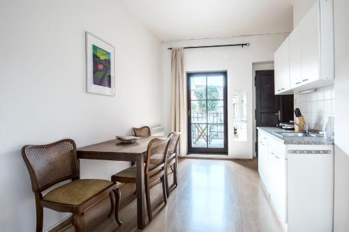 a kitchen and dining room with a wooden table and chairs at Family Apartments Praha 6 in Prague
