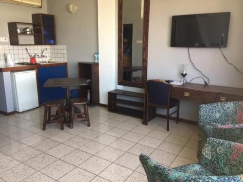 sala de estar con sofá, mesa y TV en Slipway Studios, en Dar es Salaam