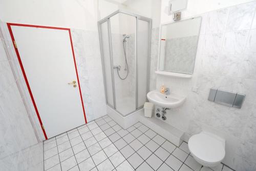 a white bathroom with a toilet and a sink at Hotel My Bed Dresden in Dresden