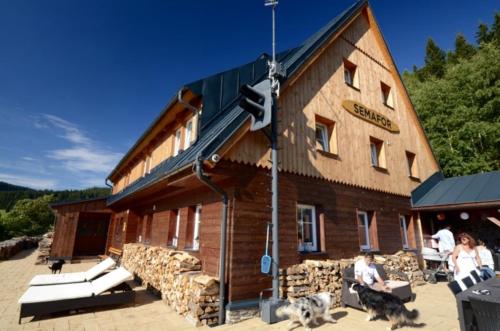 a wooden building with people sitting outside of it at Chalupa Semafor in Dolní Malá Úpa