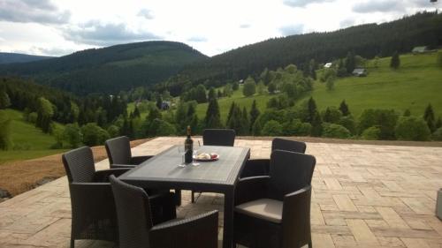 a table with chairs and a bottle of wine on it at Chalupa Semafor in Dolní Malá Úpa