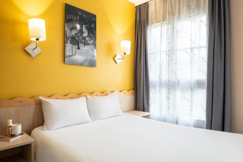 a bedroom with a bed and a window at Aparthotel Adagio Marne La Vallée - Val d'Europe in Serris