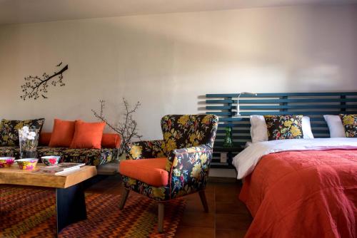 a bedroom with a bed and a couch and a chair at La Maison des Cèdres in Al Arz