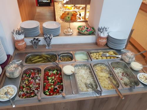 a buffet with many different types of food in trays at Heléna Hotel & SPA in Levél