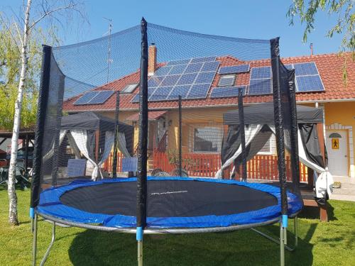 a trampoline in front of a house with solar panels at Heléna Hotel & SPA in Levél