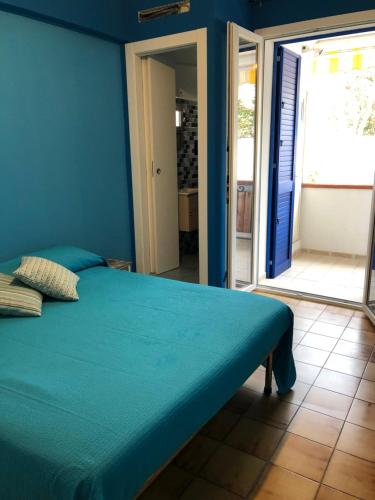 1 dormitorio azul con 1 cama con pared azul en A due passi dal mare en Realmonte