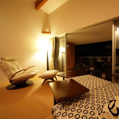 a hotel room with a bed and a chair at Four Seasons Yuzawa Quattro in Yuzawa