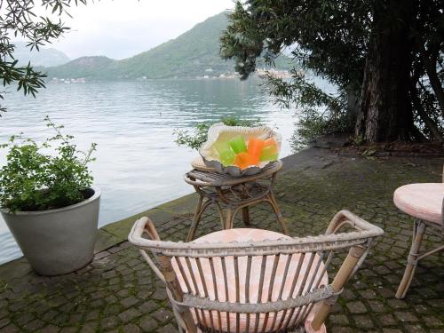 a basket of fruit sitting on a chair next to a lake at L'Oleandro sul Lago d'Iseo B&B in Sulzano