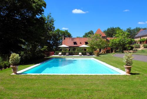 une piscine dans la cour d'une maison dans l'établissement Le Manoir du Rocher, à Domme