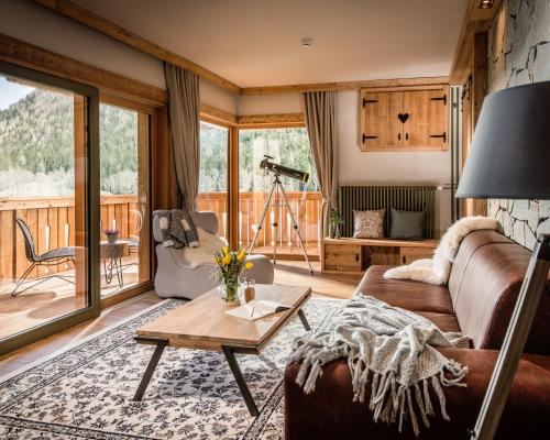 a living room with a couch and a table at Boutique hotel Vila Planinka in Zgornje Jezersko