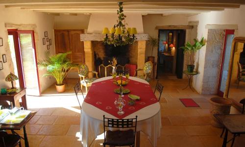 ein Esszimmer mit einem roten und weißen Tisch mit Stühlen in der Unterkunft Le Manoir du Rocher in Domme