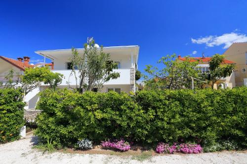 a white house with bushes in front of it at Apartments Brankica in Zadar