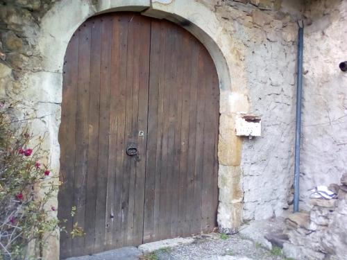 uma porta de madeira no lado de um edifício de pedra em Gîte B.Lay em Saint-Sèbastien
