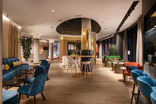a lobby with couches and tables and chairs at Vincci Consulado de Bilbao in Bilbao