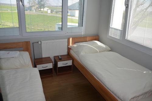 a small room with two beds and two windows at Country House Reem in Pommeuse