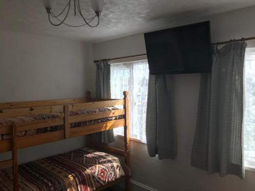 a bedroom with a bunk bed and a television on the wall at Jacaranda Hotel in Paignton