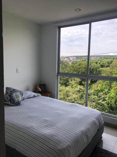 1 dormitorio con cama y ventana grande en Apartamento Nuevo y moderno, en Pereira