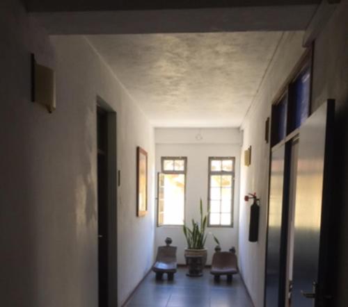einen Flur mit weißen Wänden und einen Flur mit zwei Fenstern in der Unterkunft Slipway Studios in Daressalam