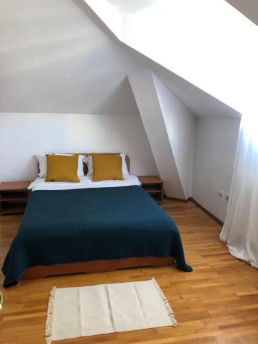 a bedroom with a bed with green sheets and yellow pillows at Casa Tomis in Constanţa