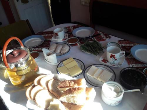 a table with bread and cups and plates of food at Dilbo House in Dilijan
