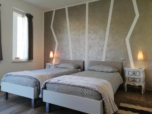 a bedroom with two beds and a window at B&B Villa Pelèr in Lazise