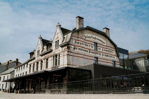 un grand bâtiment en briques avec un panneau. dans l'établissement Hotel Sanglier, à Durbuy