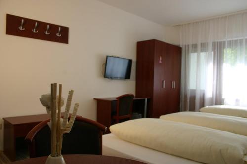 a hotel room with two beds and a tv at Apartment Traube in Bad Urach