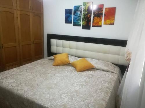 - une chambre avec un lit et 2 oreillers jaunes dans l'établissement Ven a disfrutar de una maravillosa estadía, à Sabaneta