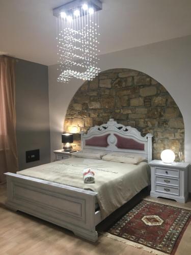 a bedroom with a large bed with a stone wall at Gesualdo da Venosa in Venosa