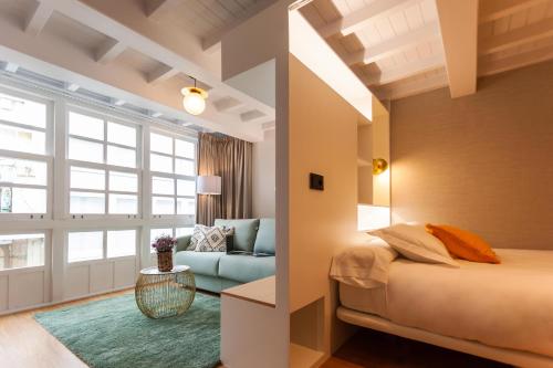 a bedroom with a bed and a couch in a room at APARTAMENTOS FRANJA 55 in A Coruña