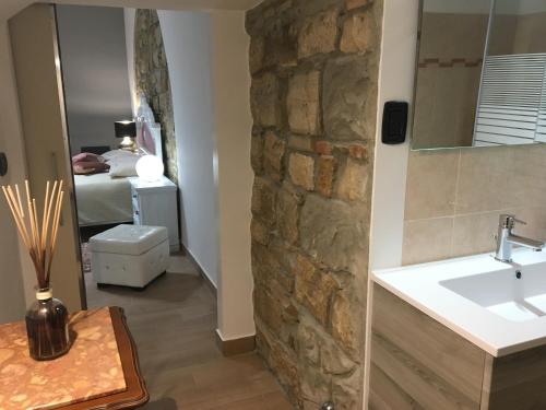 a bathroom with a sink and a stone wall at Gesualdo da Venosa in Venosa