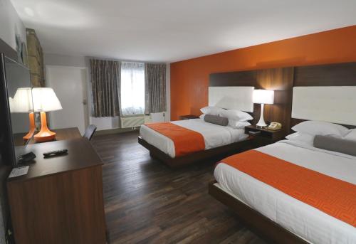 a hotel room with two beds and a desk with lamps at Howard Johnson by Wyndham Downtown Gatlinburg in Gatlinburg