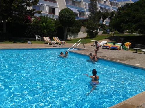 um grupo de pessoas numa piscina em Amathusia beach apartment em Limassol
